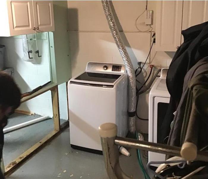 Basement with dryer and items stacked on one side