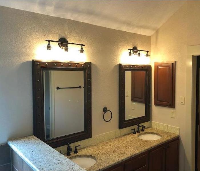Bathroom with new drywall and sinks and mirrors