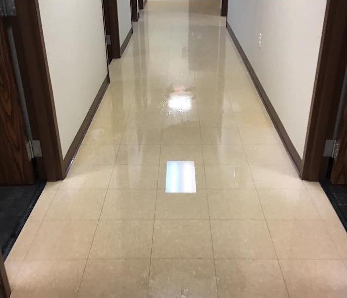 Office hallway with water on a tile floor