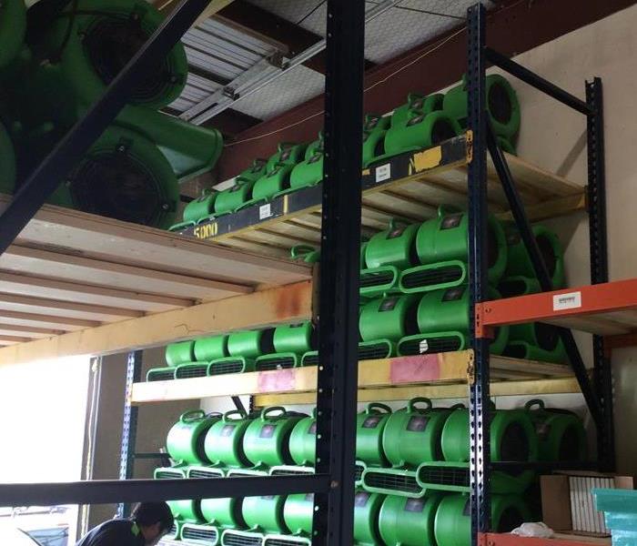 Green air movers stacked on shelves