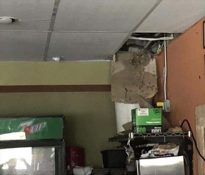 Desk and drink machine with damaged ceiling tile